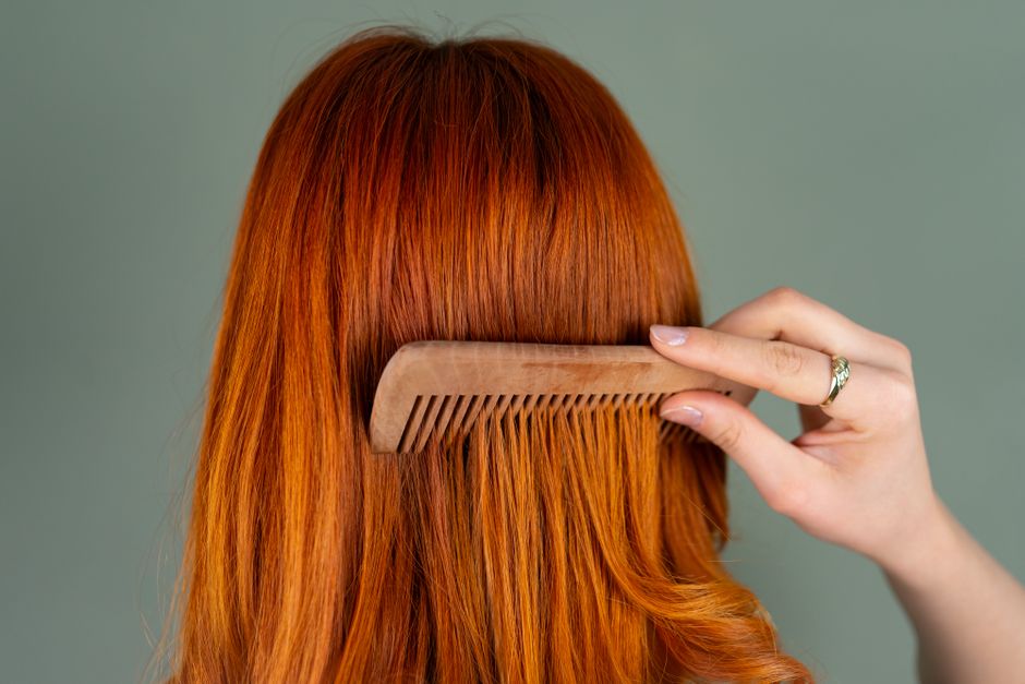 Mujer Peinándose El Pelo Largo Rojo Con Un Peine De Madera