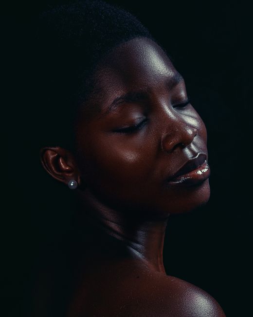 Retrato artístico de una mujer africana con los ojos cerrados, que captura una belleza serena.