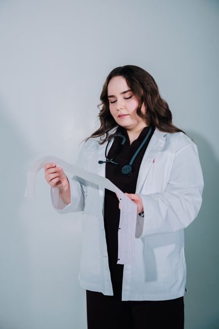 Una médica examina un informe médico en un entorno clínico.