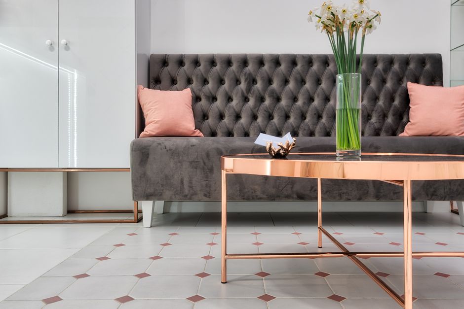 Diseño de interiores elegante con un sofá moderno y un arreglo floral en un entorno elegante.